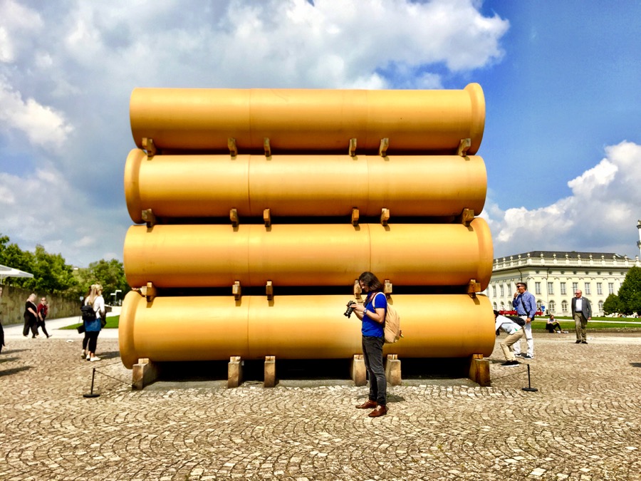 A imagem mostra canos gigantes empilhados vistos pela lateral.