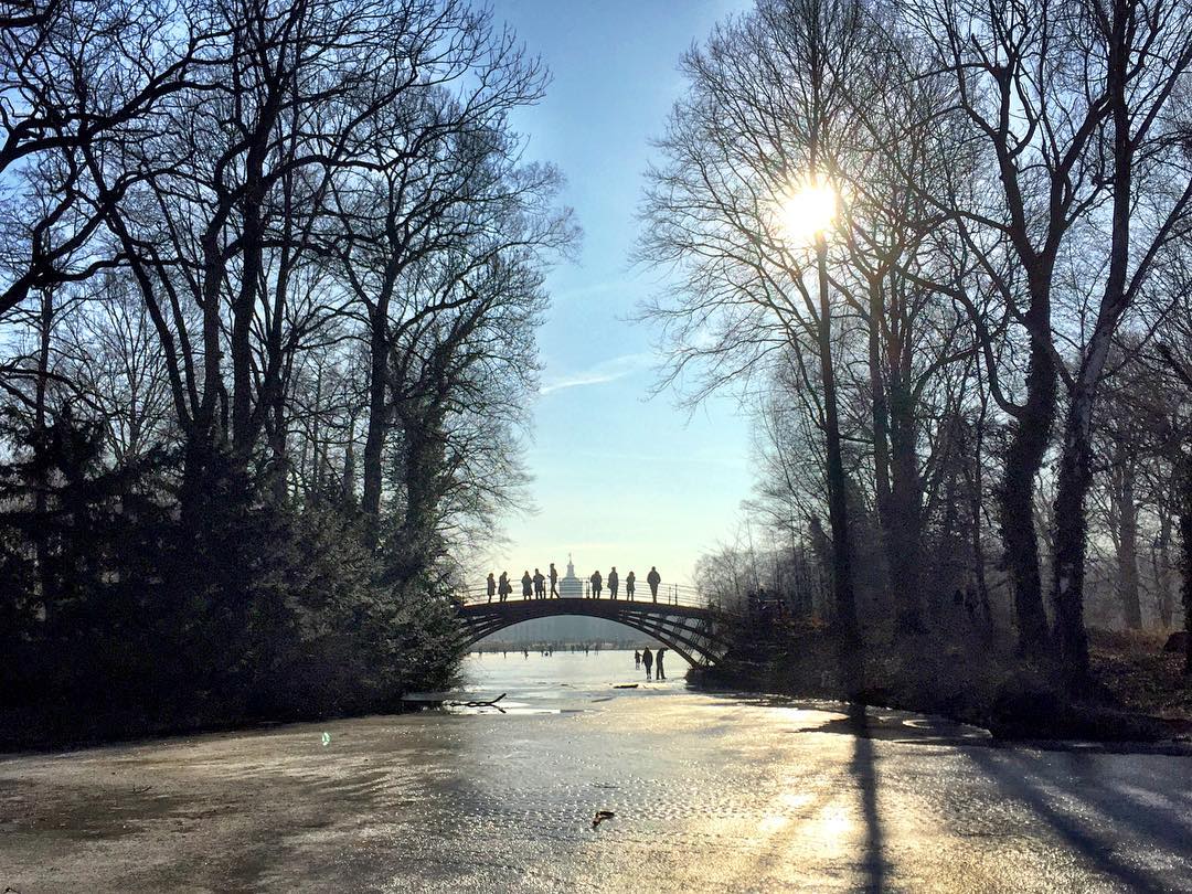 #paracegover Descrição para deficientes visuais: a imagem mostra uma ponte na parte de trás do Castelo de Charlottenburg. O lago embaixo dela está congelado. A vegetação tem apenas galhos. Muitas pessoas caminham sobre a ponte. O dia está lindo (mas a foto é do final de semana; hoje está bem nublado). — at Schlosspark Charlottenburg.