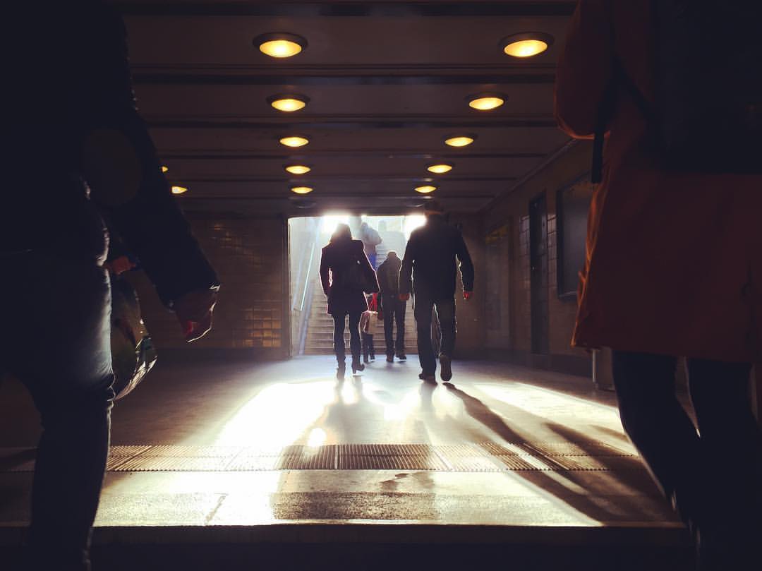 #paracegover Descrição para deficientes visuais: a imagem mostra uma cena escura (o corredor de saída da estação de metrô). Ao fundo, a escada com a luz do dia entrando. A silhueta das pessoas deu um tom de mistério... — at Märkisches Museum (Berlin U-Bahn).