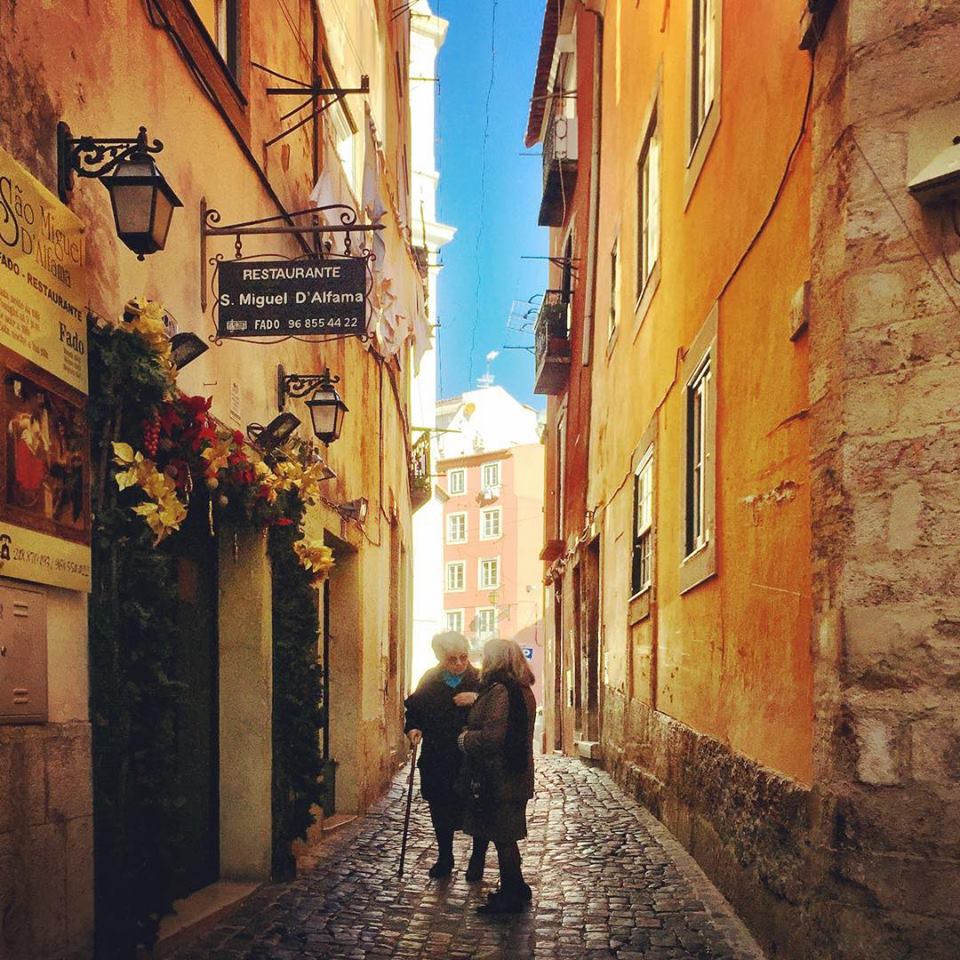 #paracegover Descrição para deficientes visuais: a imagem mostra duas senhoras portuguesas conversando em um beco do bairro Alfama. O dia está cinematográfico! — in Alfama, Lisboa, Portugal.