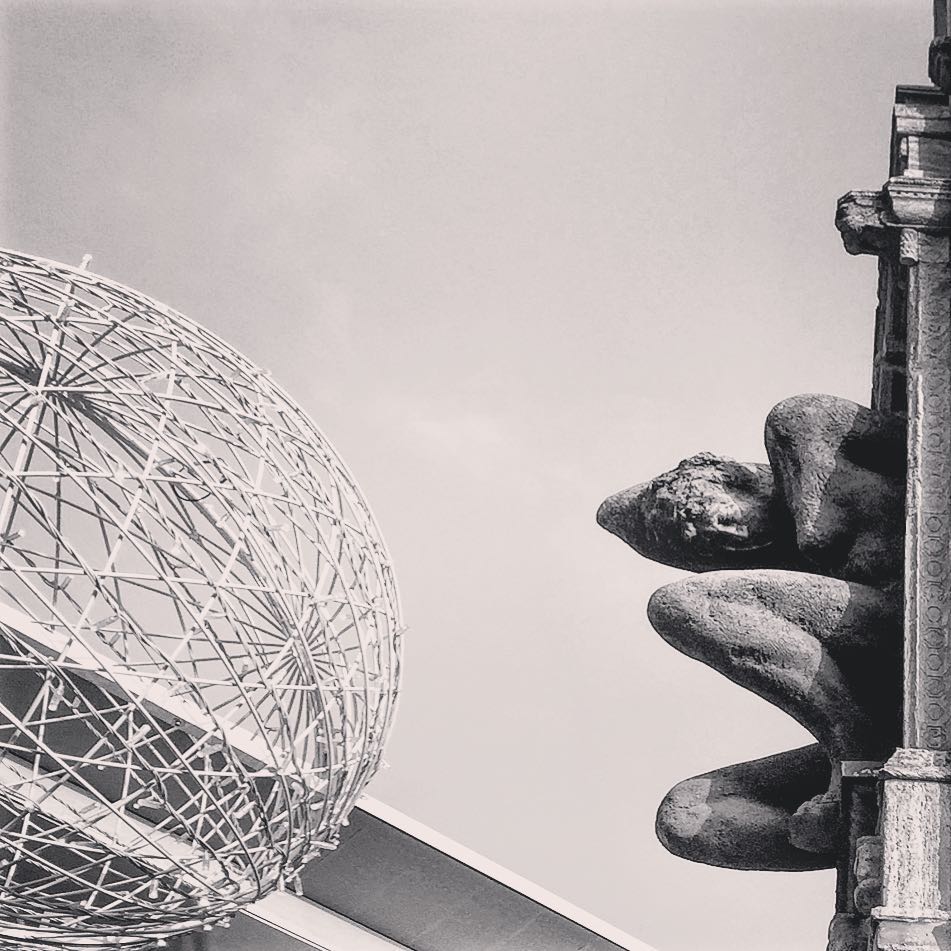  #paracegover Descrição para deficientes visuais: a imagem mostra a silhueta de uma escultura encravada na esquina de prédio representando uma mulher acocorada como se estivesse esperando o momento propício para um determinado movimento. Essa escultura sempre me fascinou e eu queria poder voar para fotografá-la de um ângulo que lhe fizesse justiça, mas, por ora, é o que temos. Do lado esquerdo, um globo construído em estrutura de arame, parte da decoração de natal que ainda não foi retirada. — at Starbucks Deutschland.