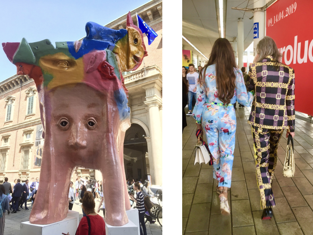 #paracegover: a imagem mostra duas fotos, sendo a primeira das duas fotos mostra uma escultura em forma de cabeça com quatro pernas e a segunda, um casal caminhando de costas. Ela com um macacão azul claro estampado com flores e anjos, bolsa e sapatos de marca e ele com um terno xadrez em roxo e preto com a palavra MOSCHINO escrita em amarelo em todas as faixas. A bolsa também é de marca e a sola do sapato vermelha leva a crer que é um legítimo Louboutin. Não por acaso, estavam saindo do pavilhão Lux... 