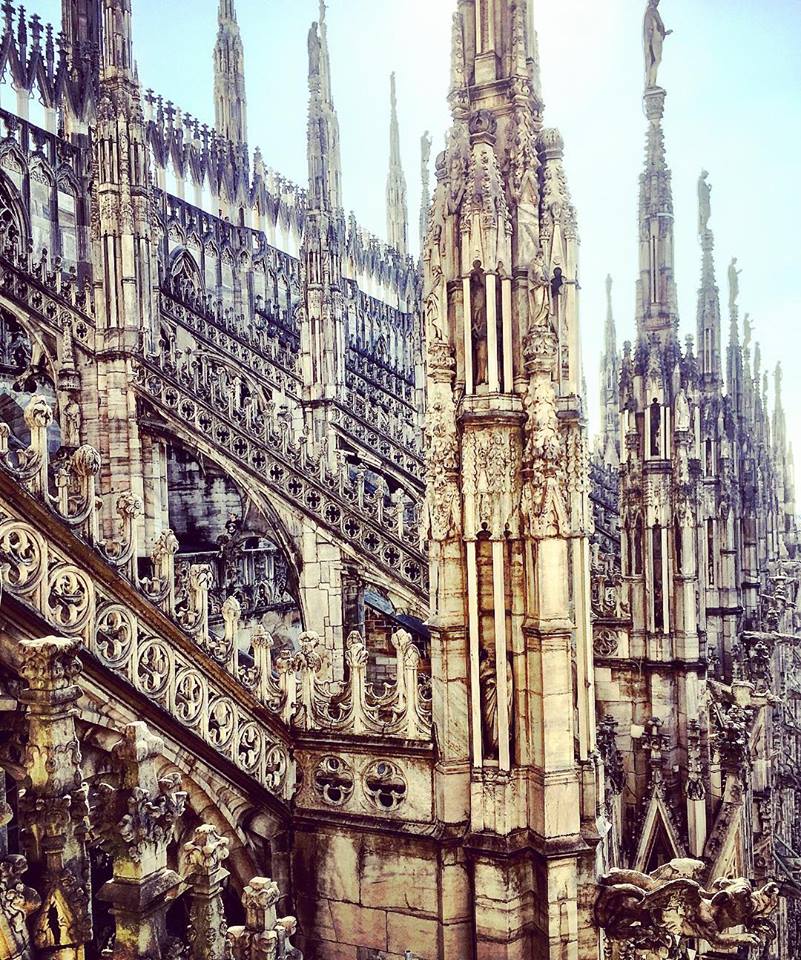 #paracegover Descrição para deficientes visuais: a imagem mostra detalhes arquitetônicos da Duomo de Milão, toda em estilo gótico e cheia de pontas, como se fossem estalagmites. Impressionante.