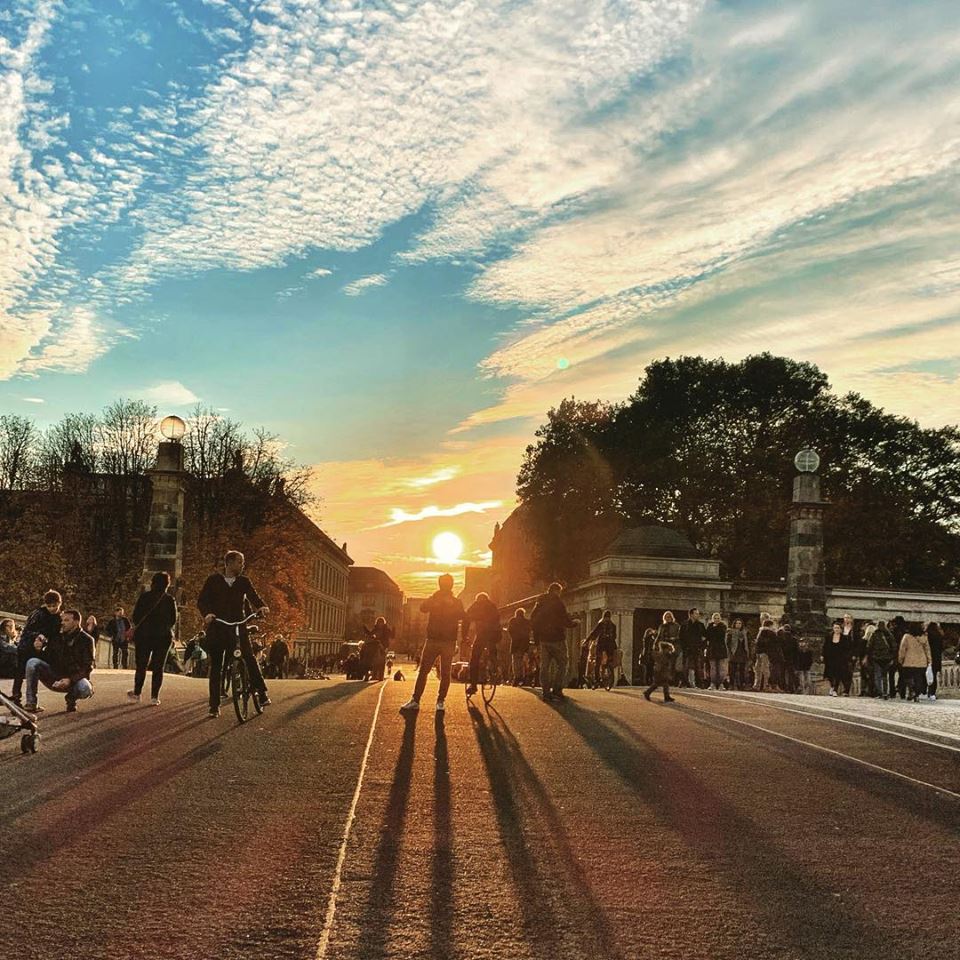 #paracegover Descrição para deficientes visuais: a imagem mostra pessoas em cima de uma ponte contra a luz do sol, que está se pondo. — at Friedrichsbrücke Berlin.